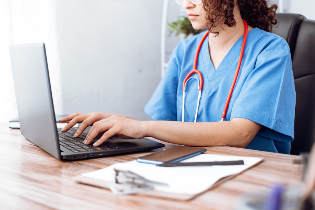nurse using computer to look up nursing certifications